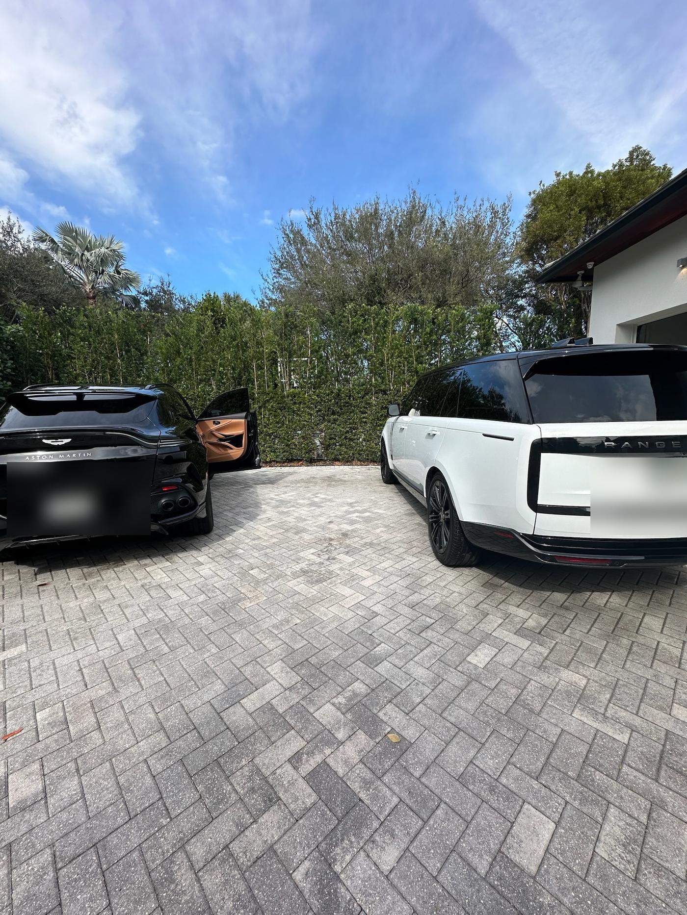 Black Aston Martin and white Range Rover after mobile detail, driveway