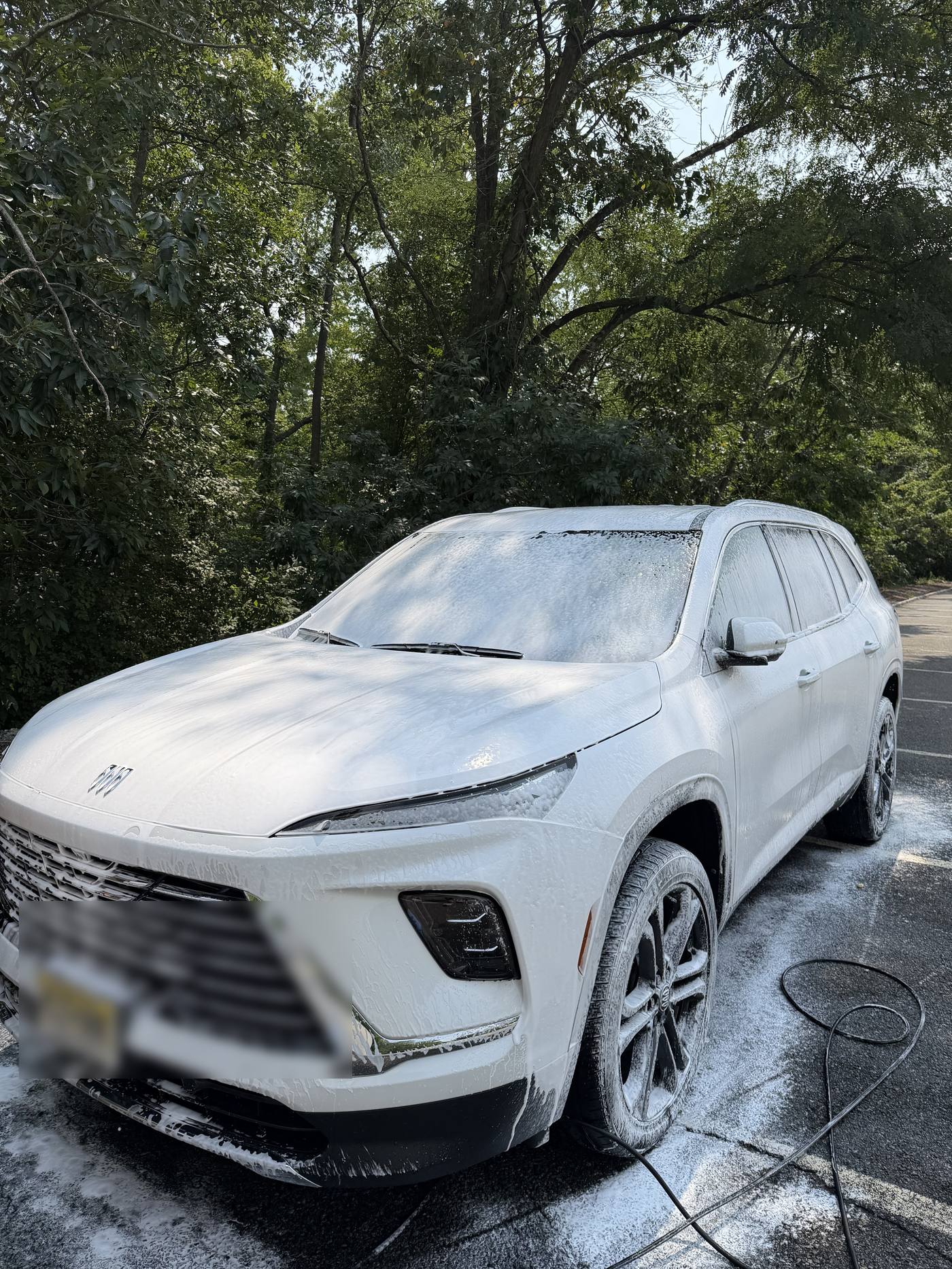 White Jeep Grand Cherokee covered in foam during a mobile detail wash